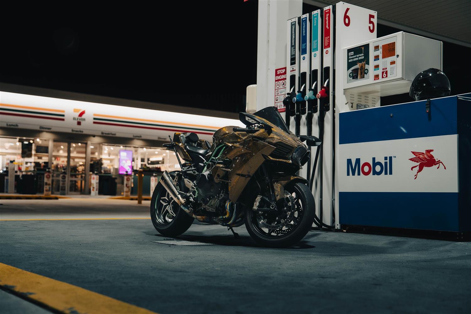 A gold sportbike at a service station at dusk